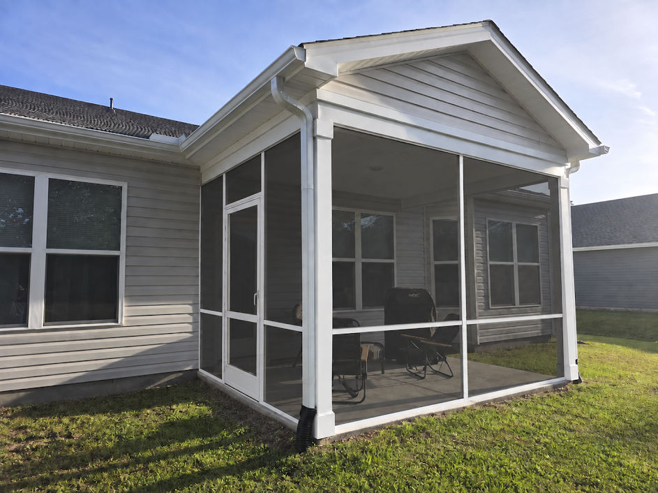 White-framed screened porch enclosure on a gray coastal home
