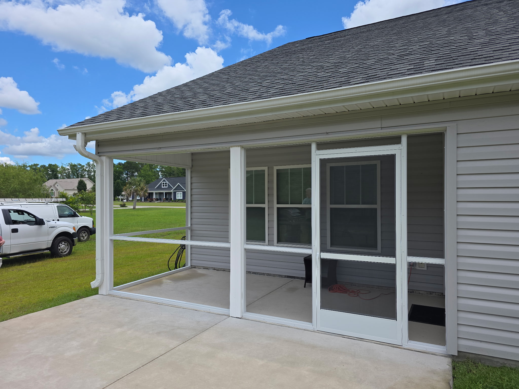 Close view of a completed white screened porch frame and door